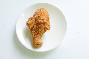 Sulu ve lezzetli tavuk budu ya da kızarmış tavuk budu, kızarmış tavuk budu beyaz seramik bir tabakta kızarmış tavuk bacağı, beyaz bir arka planda izole edilmiş.