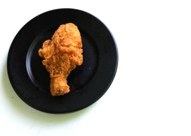 Sulu ve lezzetli tavuk budu ya da kızarmış tavuk budu, kızarmış tavuk budu ahşap bir kapta kızarmış tavuk bacağı siyah bir arka planda izole edilmiş.