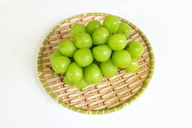 Bir demet taze Sweet Green Shine Muscat (Vitis vinifera) üzümü ahşap sepeti izole ediyor. Japon üzümleri. Üzüm yeşili. Tadı tatlı ve doğal..