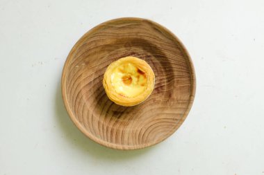 Taze yumurtalı tart fırında tatlı tatlı tatlı, Pastel de nata turtası ya da Portekiz turtası ahşap bir platoda beyaz bir zemin üzerinde..