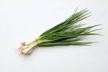 Bir demet taze çiğ taze soğan, yeşil soğan (allium cepa var. Kökleri beyaz arkaplanda izole edilmiş. sağlıklı sebze konsepti