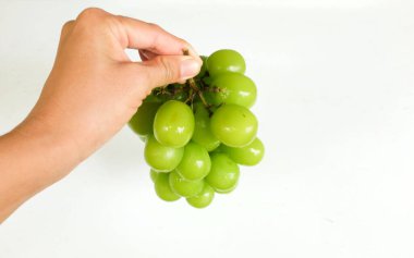 Bir demet taze Sweet Green Shine Muscat (Vitis vinifera) üzümü ahşap sepeti izole ediyor. Japon üzümleri. Üzüm yeşili. Tadı tatlı ve doğal..