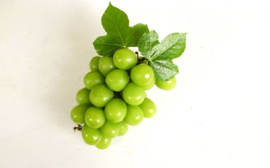 Bir demet taze Sweet Green Shine Muscat (Vitis vinifera) üzümü ahşap sepeti izole ediyor. Japon üzümleri. Üzüm yeşili. Tadı tatlı ve doğal..