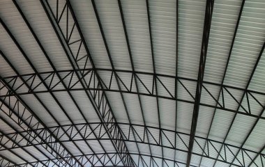 Çelik çatı iskeletinin kiremit çatıyla kaplı olduğu bir yapıyı kapatın. Çatı kiremit kaplama, altında metal bir yapı ve fotokopi alanı var. seçici odak