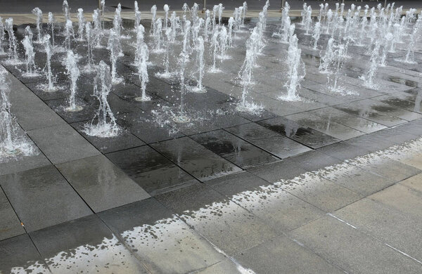 beautiful View of a water fountain at the Fountain Water Texture Background, Falling Fresh Fountain Jets, Waterfall Splash Pattern entrance of the  shopping mall , in Bangkok, Thailand.