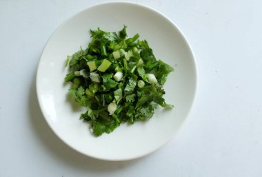 Taze doğranmış yeşil soğan ve kişniş beyaz tabak malzemesi içinde Tayland mutfağı beyaz arka planda izole edilir.