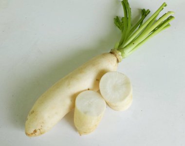 Dilimlenmiş taze beyaz daikon, daikon turp, turp, beyaz turp, (raphanus sativus var. Beyaz bir arka planda izole edilmiş. Sağlıklı yemek pişirmek için sebze hazırlıyorum.