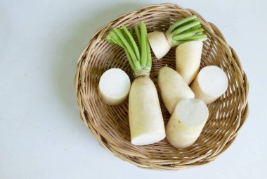 Sliced fresh white daikon, daikon radish, radish, white radish,(raphanus sativus var. longipinnatus)  isolated On a wooden tray.Preparing vegetables for healthy cooking clipart