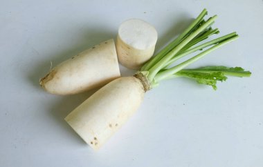 Dilimlenmiş taze beyaz daikon, daikon turp, turp, beyaz turp, (raphanus sativus var. Beyaz bir zemin üzerinde izole edilmiş. Sebzeleri sağlıklı pişirmeye hazırlıyorum.