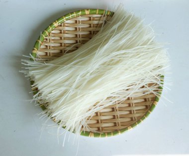 top view and flat lay a dried uncooked rice noodles ,dried raw rice noodles ,Thai dried rice noodles In a wooden basket isolated on white backdrop clipart