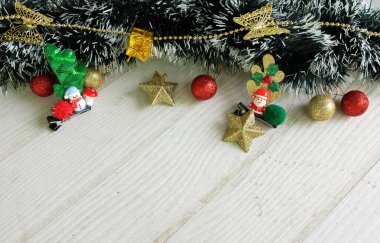 Noel ağacının süslenmiş yeşil köknar dallarından Noel Baba Cos, ışıl ışıl Noel topları, çam kozalakları beyaz tahta bir arka planda sevimli kardan adam.. 