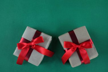 Set of Christmas gifts wrapped in craft paper ,Handmade gifts on a green backdrop. Christmas gifts and red Christmas bows with place for text. gift from Holiday mood. New year chrismas decor.  clipart