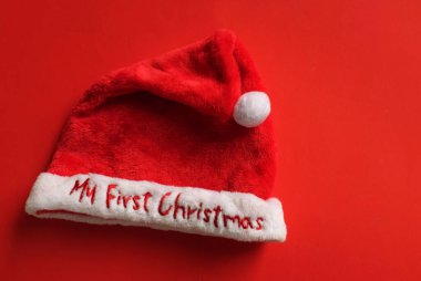 bright cute red santa claus hat isolate on red backdrop.concept of joyful christmas party,new year is coming soon, festive season decoration with christmas elements clipart