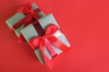 El işi kağıdına sarılı Noel hediyeleri, kırmızı arka planda el yapımı hediyeler. Noel hediyeleri ve kırmızı Noel yayları. Bayram havasından bir hediye. Yeni yıl Noel dekoru. 