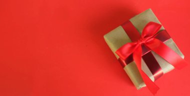 El işi kağıdına sarılı Noel hediyeleri, kırmızı arka planda el yapımı hediyeler. Noel hediyeleri ve kırmızı Noel yayları. Bayram havasından bir hediye. Yeni yıl Noel dekoru. 