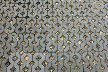 Gri asfalt döşemek için tuğla bloklar. Eşkenar dörtgende gri fayans, üçgen şeklinde kum, kaldırım döşeme dokusu arka planda taş döşeme.