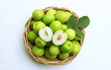 taze çiğ yeşil sulu lezzetli süt jujubası, Tayvan Süt Jujubası, Hint Jujube meyvesi (Ziziphus juba Mill) meyve, süt jujujujubisi ikiye bölünmüş ahşap bir sepette ve beyaz arka planda yeşil yapraklar