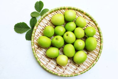  taze çiğ yeşil sulu lezzetli süt jubası, Tayvan Süt Jujubası, Hint Jujube meyvesi (Ziziphus juba Mill) meyvesi, Süt jujujubası Tahta tepsilerde yeşil yapraklarla yalıtılmış beyaz arka planda