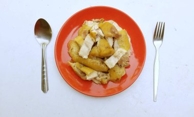 Sarı haşlanmış tavuk kırmızı bir tabakta parçalara bölünmüş ve beyaz bir arka planda izole edilmeye hazır. Tayland yemeği..