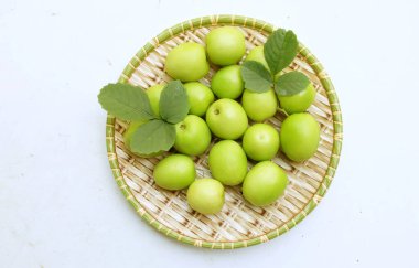 taze çiğ, sulu, lezzetli süt jujubası, kuyruk sütü jujubası, Hint jube meyvesi (ziziphus juba değirmeni) meyve, ikiye bölünmüş süt jubası beyaz bir zemin üzerinde izole edilmiş ahşap tepsilerde