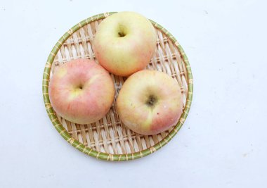 Taze kırmızı meyveli tatlı elma (Malus domestica Borkh) beyaz arka planda izole edilmiş ahşap bir tepside. Sağlıklı meyveler.