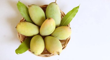 Taze organik Barakuda Mango, Nam Dok Mai, Altın Mango, Sarı Mango (Mangifera indica Linn). Hasır bir sepetteki mango meyveleri beyaz bir zeminde izole edilmiş yapraklarla. Tayland 'da tropik meyve ve egzotik