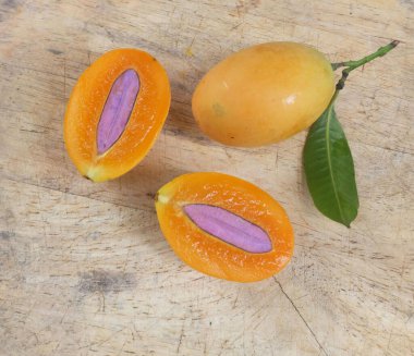 Üst ve düz taze taze tatlı olgun Marian erik yığını Tayland meyvesi bir ahşap zemin üzerinde izole (mayongchid maprang marian erik ve erik mango, thailand) yatıyordu. Tayland 'ın sağlıklı meyveleri.