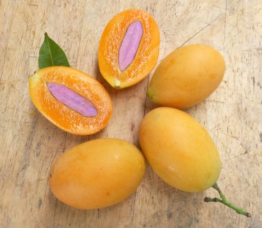 Üst ve düz taze taze tatlı olgun Marian erik yığını Tayland meyvesi bir ahşap zemin üzerinde izole (mayongchid maprang marian erik ve erik mango, thailand) yatıyordu. Tayland 'ın sağlıklı meyveleri.