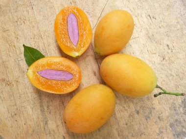 Üst ve düz taze taze tatlı olgun Marian erik yığını Tayland meyvesi bir ahşap zemin üzerinde izole (mayongchid maprang marian erik ve erik mango, thailand) yatıyordu. Tayland 'ın sağlıklı meyveleri.