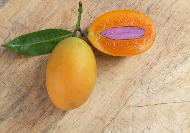 Üst ve düz taze taze tatlı olgun Marian erik yığını Tayland meyvesi bir ahşap zemin üzerinde izole (mayongchid maprang marian erik ve erik mango, thailand) yatıyordu. Tayland 'ın sağlıklı meyveleri.