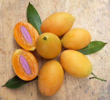 Üst ve düz taze taze tatlı olgun Marian erik yığını Tayland meyvesi bir ahşap zemin üzerinde izole (mayongchid maprang marian erik ve erik mango, thailand) yatıyordu. Tayland 'ın sağlıklı meyveleri.