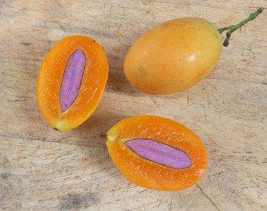 Üst ve düz taze taze tatlı olgun Marian erik yığını Tayland meyvesi bir ahşap zemin üzerinde izole (mayongchid maprang marian erik ve erik mango, thailand) yatıyordu. Tayland 'ın sağlıklı meyveleri.