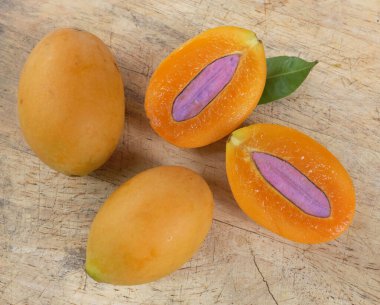 Üst ve düz taze taze tatlı olgun Marian erik yığını Tayland meyvesi bir ahşap zemin üzerinde izole (mayongchid maprang marian erik ve erik mango, thailand) yatıyordu. Tayland 'ın sağlıklı meyveleri.