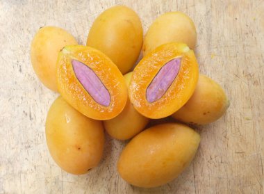 Üst ve düz taze taze tatlı olgun Marian erik yığını Tayland meyvesi bir ahşap zemin üzerinde izole (mayongchid maprang marian erik ve erik mango, thailand) yatıyordu. Tayland 'ın sağlıklı meyveleri.