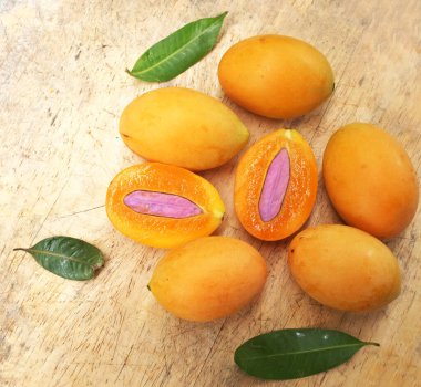 Üst ve düz taze taze tatlı olgun Marian erik yığını Tayland meyvesi bir ahşap zemin üzerinde izole (mayongchid maprang marian erik ve erik mango, thailand) yatıyordu. Tayland 'ın sağlıklı meyveleri.