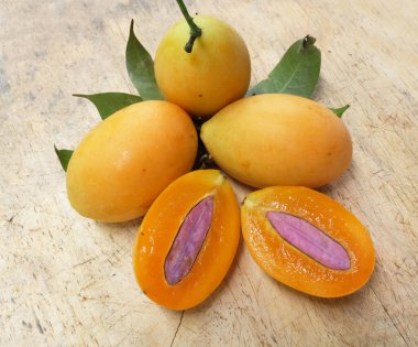 Üst ve düz taze taze tatlı olgun Marian erik yığını Tayland meyvesi bir ahşap zemin üzerinde izole (mayongchid maprang marian erik ve erik mango, thailand) yatıyordu. Tayland 'ın sağlıklı meyveleri.