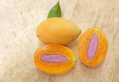 Üst ve düz taze taze tatlı olgun Marian erik yığını Tayland meyvesi bir ahşap zemin üzerinde izole (mayongchid maprang marian erik ve erik mango, thailand) yatıyordu. Tayland 'ın sağlıklı meyveleri.