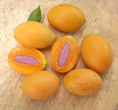 Üst ve düz taze taze tatlı olgun Marian erik yığını Tayland meyvesi bir ahşap zemin üzerinde izole (mayongchid maprang marian erik ve erik mango, thailand) yatıyordu. Tayland 'ın sağlıklı meyveleri.