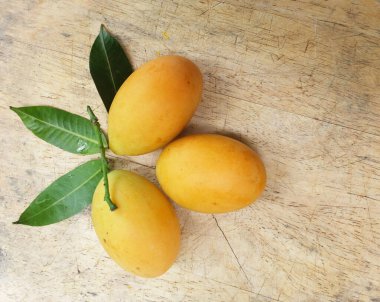 Üst ve düz taze taze tatlı olgun Marian erik yığını Tayland meyvesi bir ahşap zemin üzerinde izole (mayongchid maprang marian erik ve erik mango, thailand) yatıyordu. Tayland 'ın sağlıklı meyveleri.