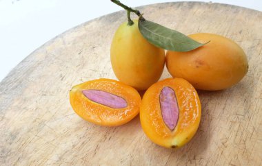 Üst ve düz taze taze tatlı olgun Marian erik yığını Tayland meyvesi bir ahşap zemin üzerinde izole (mayongchid maprang marian erik ve erik mango, thailand) yatıyordu. Tayland 'ın sağlıklı meyveleri.