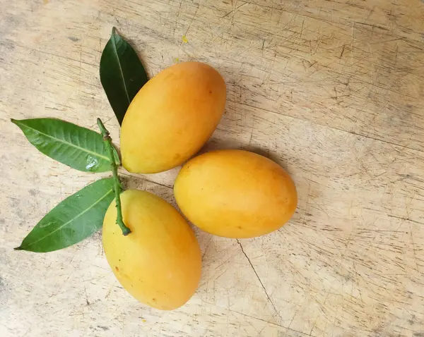 Üst ve düz taze taze tatlı olgun Marian erik yığını Tayland meyvesi bir ahşap zemin üzerinde izole (mayongchid maprang marian erik ve erik mango, thailand) yatıyordu. Tayland 'ın sağlıklı meyveleri.