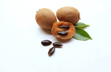 Yarı kesilmiş ve yeşil yapraklı bir grup taze organik tatlı meyve, sapodilla eriği, sapota (l) p. royen), sapodilla, sawo beyaz zemin üzerinde izole edilmiş.