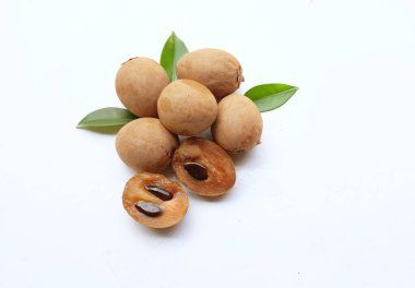 Yarı kesilmiş ve yeşil yapraklı bir grup taze organik tatlı meyve, sapodilla eriği, sapota (l) p. royen), sapodilla, sawo beyaz zemin üzerinde izole edilmiş.