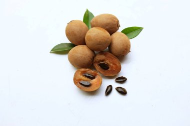Yarı kesilmiş ve yeşil yapraklı bir grup taze organik tatlı meyve, sapodilla eriği, sapota (l) p. royen), sapodilla, sawo beyaz zemin üzerinde izole edilmiş.