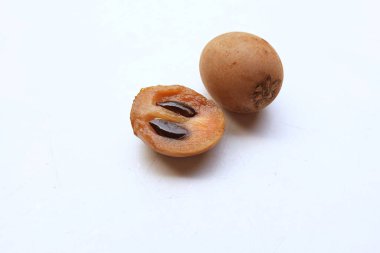 Yarı kesilmiş ve yeşil yapraklı bir grup taze organik tatlı meyve, sapodilla eriği, sapota (l) p. royen), sapodilla, sawo beyaz zemin üzerinde izole edilmiş.