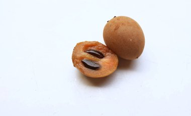 Yarı kesilmiş ve yeşil yapraklı bir grup taze organik tatlı meyve, sapodilla eriği, sapota (l) p. royen), sapodilla, sawo beyaz zemin üzerinde izole edilmiş.