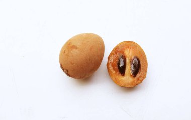 Yarı kesilmiş ve yeşil yapraklı bir grup taze organik tatlı meyve, sapodilla eriği, sapota (l) p. royen), sapodilla, sawo beyaz zemin üzerinde izole edilmiş.