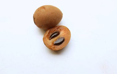 Yarı kesilmiş ve yeşil yapraklı bir grup taze organik tatlı meyve, sapodilla eriği, sapota (l) p. royen), sapodilla, sawo beyaz zemin üzerinde izole edilmiş.