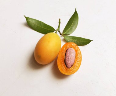 Üst ve düz taze tatlı olgun Marian eriği yığını Tayland meyvesi beyaz bir zemin üzerinde izole (mayongchid maprang marian erik ve erik mango, thailand). Tayland 'ın sağlıklı meyveleri