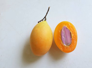 Üst ve düz taze tatlı olgun Marian eriği yığını Tayland meyvesi beyaz bir zemin üzerinde izole (mayongchid maprang marian erik ve erik mango, thailand). Tayland 'ın sağlıklı meyveleri